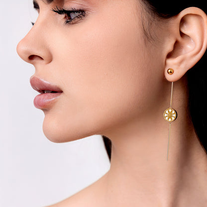 Close-up of a woman wearing gold earrings, The Ravenna White Mother of Pearl 3-in-1 Long Earring in 18kt Yellow Gold. She is wearing the vintage look drop earring.