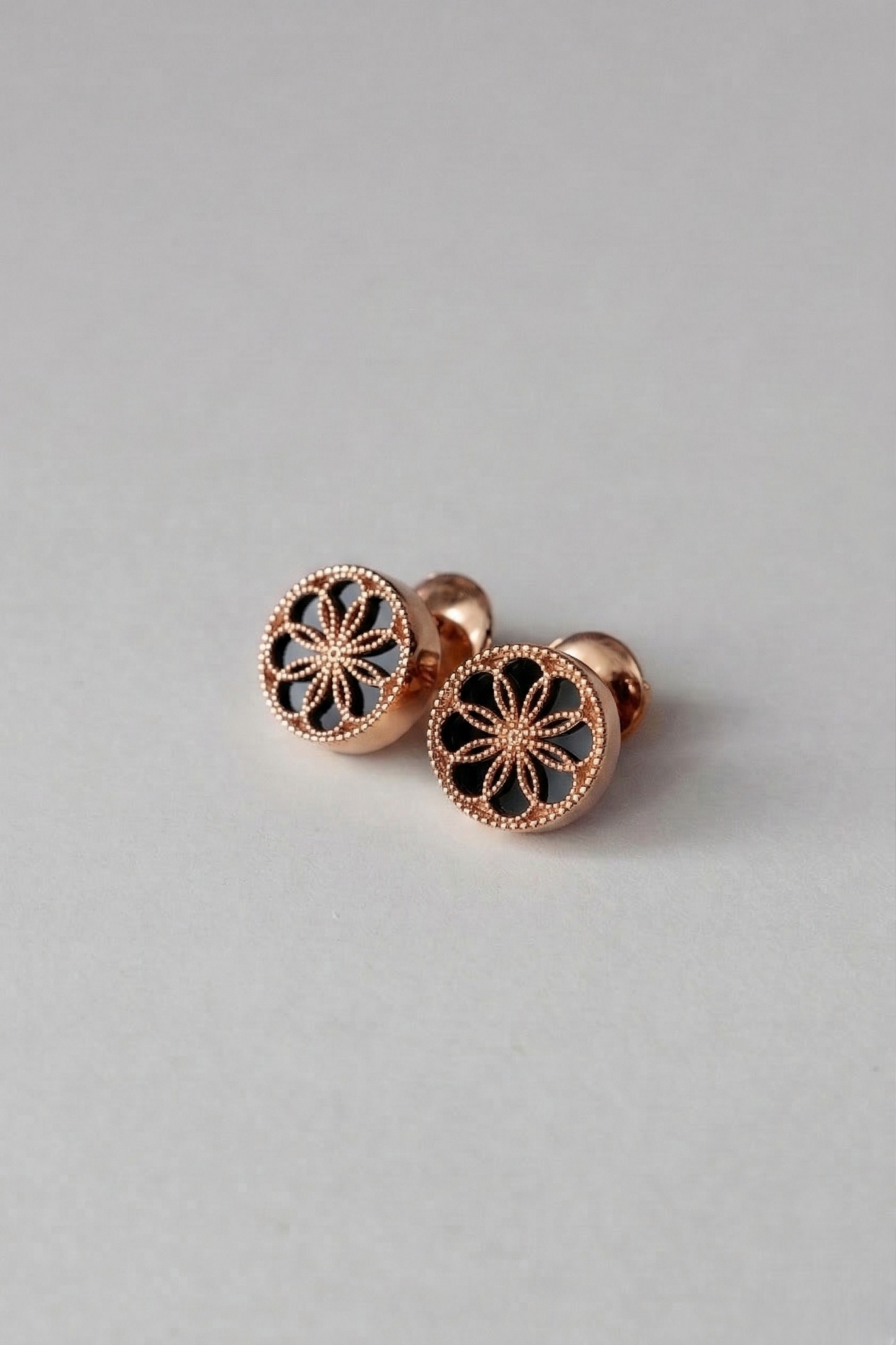 A pair of Gold earrings with a byzantine inspired design. The Ravenna Black Onyx Stud Earrings in 18kt Rose Gold. 